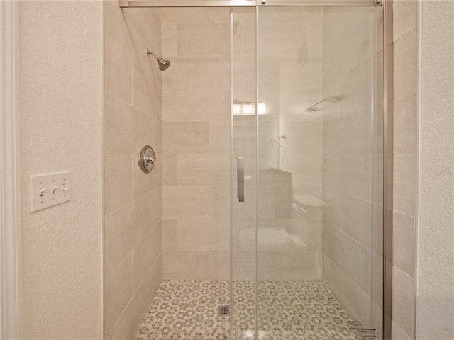 bathroom with a shower with door