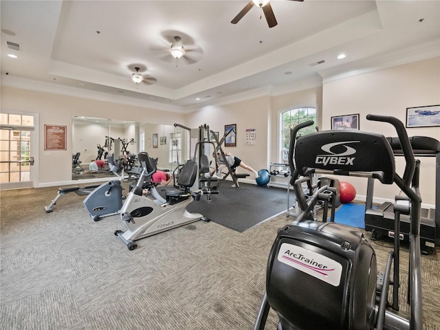 exercise room featuring ceiling fan, a tray ceiling, and crown molding