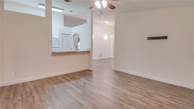 unfurnished living room featuring ceiling fan and light hardwood / wood-style flooring