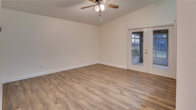 empty room featuring vaulted ceiling, ceiling fan, light hardwood / wood-style flooring, and french doors