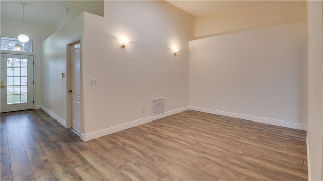 interior space with wood-type flooring and high vaulted ceiling