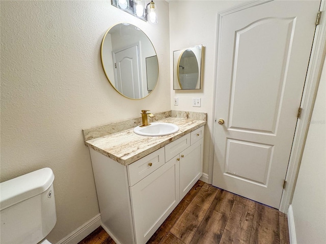 bathroom featuring hardwood / wood-style flooring, toilet, and vanity