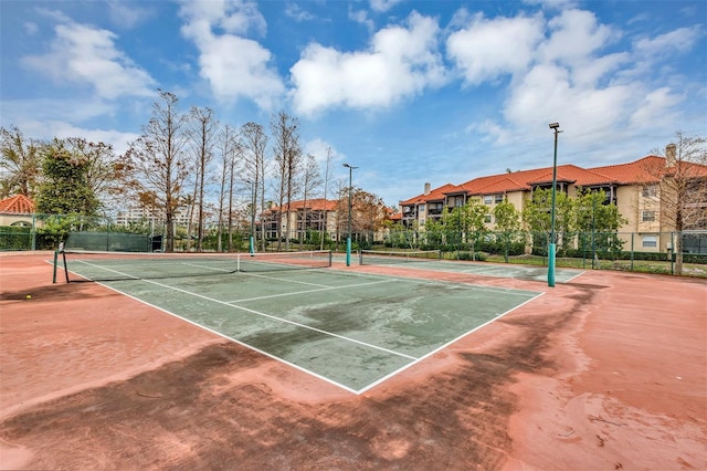 view of sport court with a residential view and fence