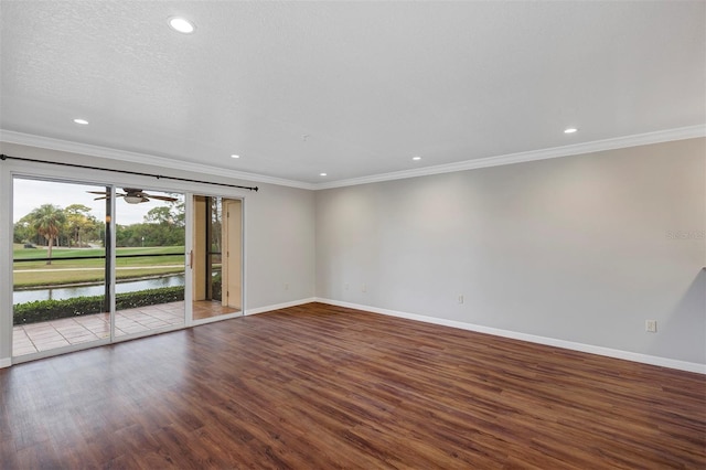 unfurnished room featuring ornamental molding, a water view, wood finished floors, and baseboards