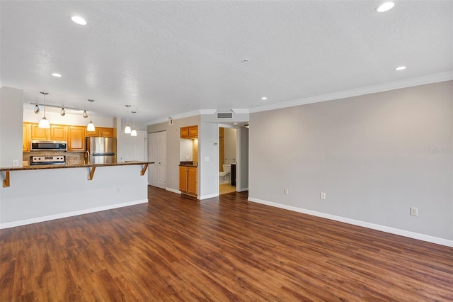 unfurnished living room featuring a textured ceiling, dark wood-style flooring, visible vents, baseboards, and ornamental molding