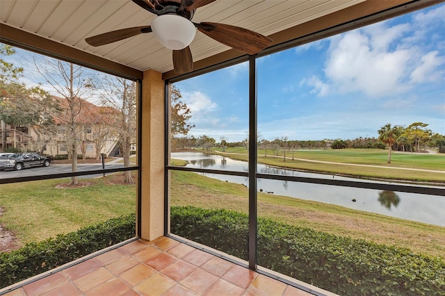 unfurnished sunroom featuring a water view and a ceiling fan