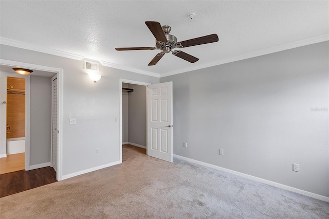 unfurnished bedroom featuring baseboards, carpet floors, visible vents, and crown molding