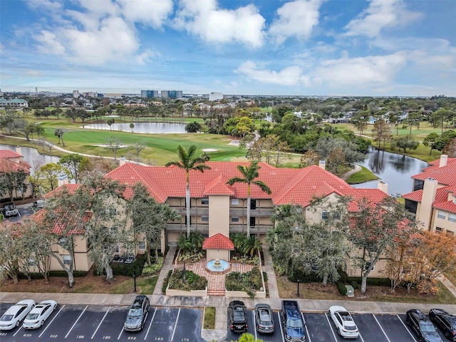 aerial view with golf course view and a water view