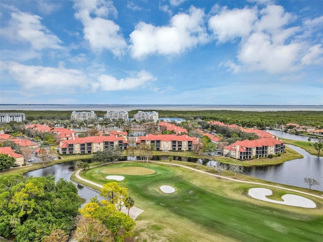 aerial view with golf course view and a water view