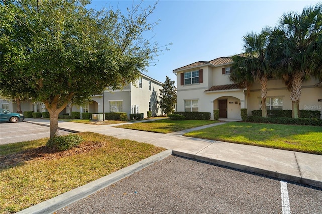 mediterranean / spanish-style house with a front yard