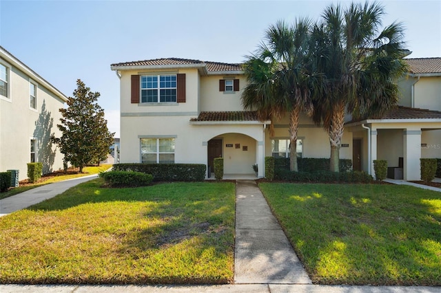 mediterranean / spanish home featuring a front yard