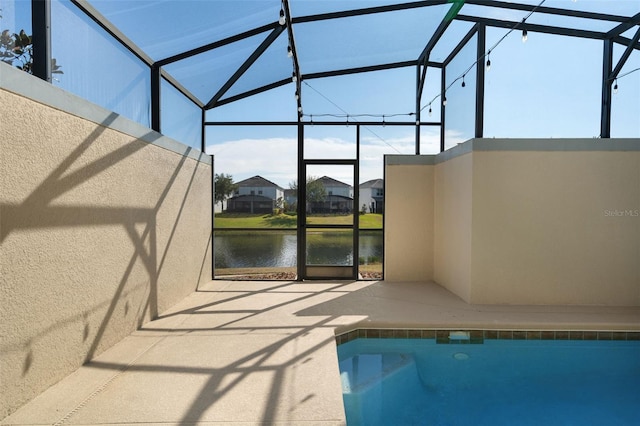 view of pool with a patio, a water view, and glass enclosure