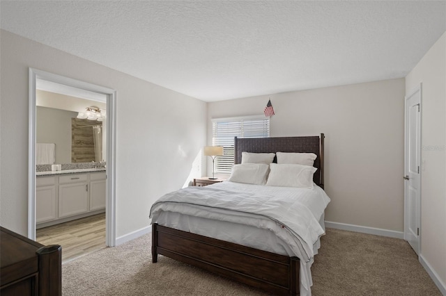 carpeted bedroom featuring a textured ceiling and connected bathroom