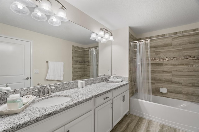 bathroom with a textured ceiling, vanity, shower / bath combo, and hardwood / wood-style flooring