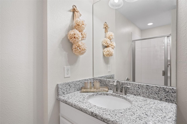 bathroom featuring vanity and a shower with shower door