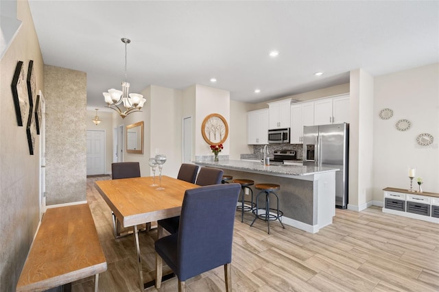 dining area featuring a notable chandelier and light hardwood / wood-style flooring