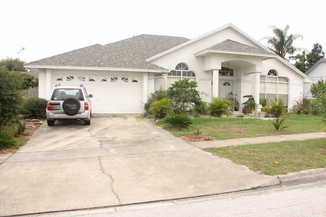 ranch-style house with a garage and a front lawn