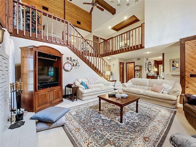 living room with ceiling fan, beam ceiling, and a towering ceiling