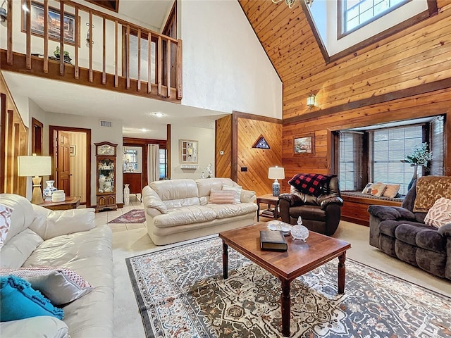 living room featuring a healthy amount of sunlight, a towering ceiling, and wood walls