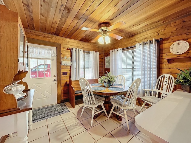 tiled dining area with ceiling fan, wood walls, and wooden ceiling