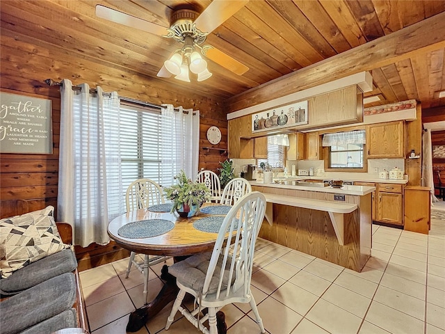 tiled dining area with ceiling fan and wooden walls