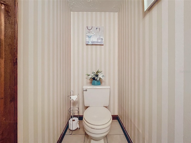 bathroom featuring toilet, tile patterned flooring, and a textured ceiling