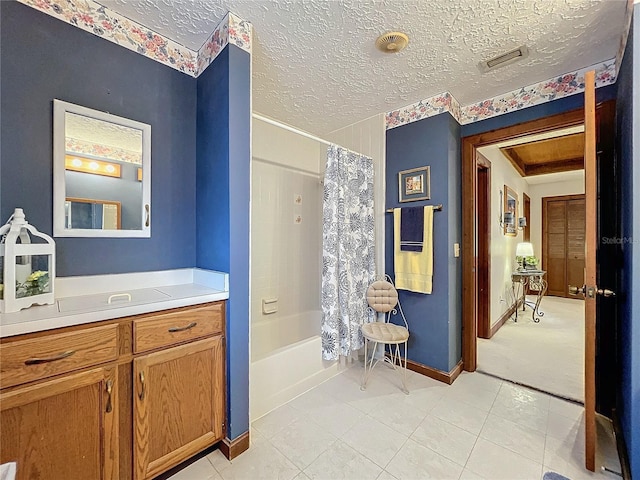 bathroom with a textured ceiling, vanity, and shower / bath combo with shower curtain