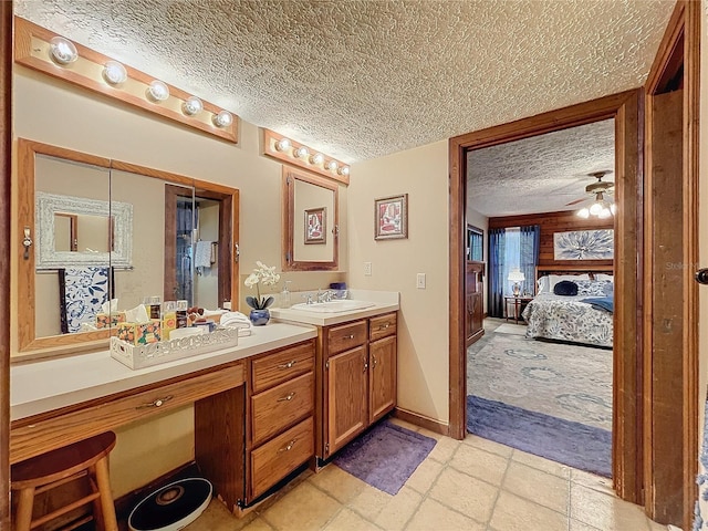 bathroom with ceiling fan, a textured ceiling, and vanity