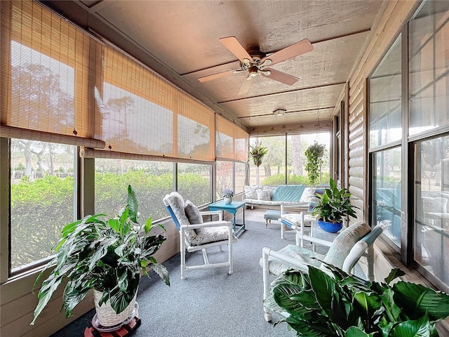 sunroom with ceiling fan, a healthy amount of sunlight, and wood ceiling