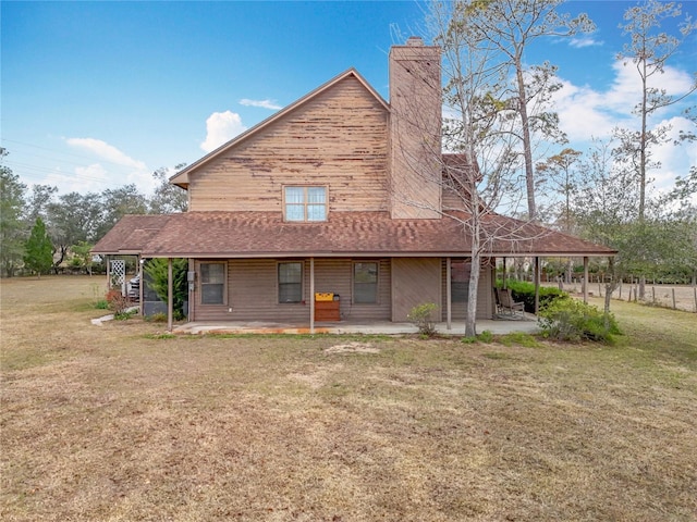 rear view of house featuring a patio area and a yard