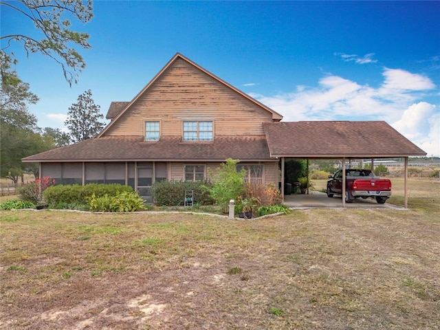 view of front of property featuring a front lawn, a sunroom, and a carport