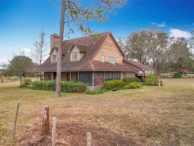 view of side of home with a yard and a sunroom