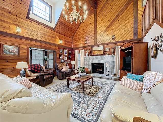 living room with a notable chandelier, a fireplace, wooden walls, and high vaulted ceiling