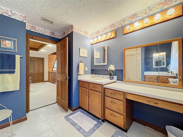 bathroom featuring a textured ceiling and vanity