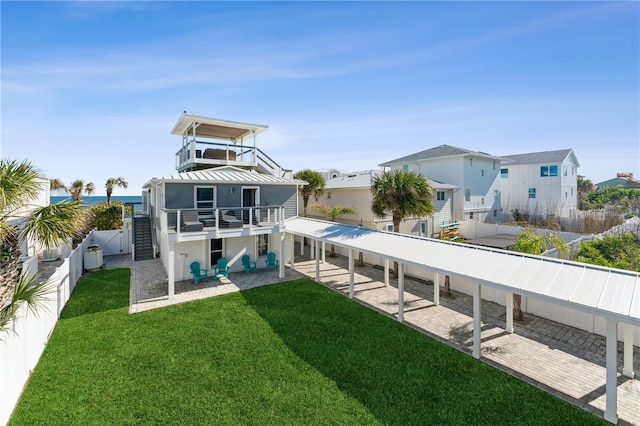 rear view of property with a patio area, a yard, and a balcony