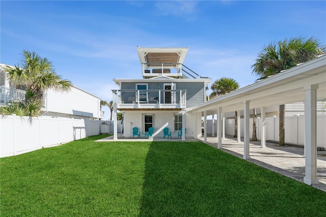 rear view of house featuring a yard, a balcony, and a patio