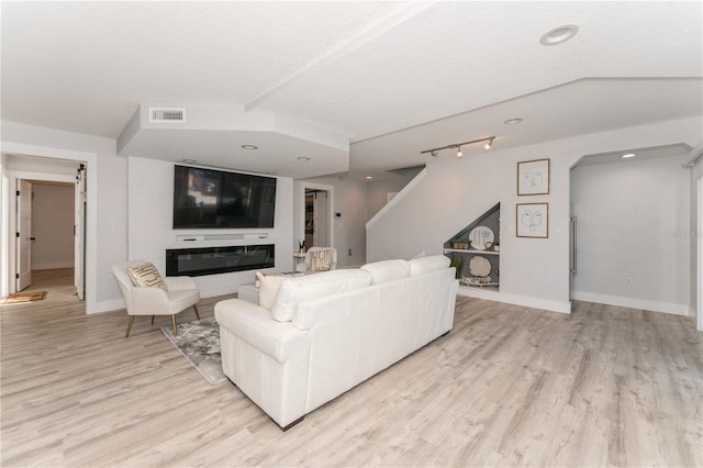 living room featuring a textured ceiling and light hardwood / wood-style floors