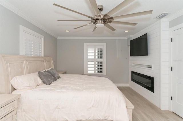 bedroom featuring ceiling fan, light wood-type flooring, and crown molding