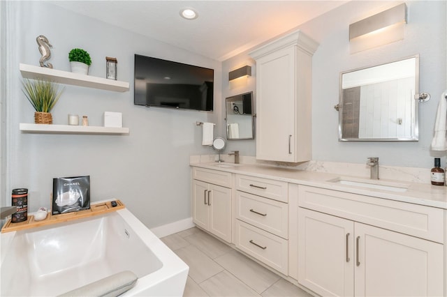 bathroom with a bathtub, vanity, and tile patterned flooring