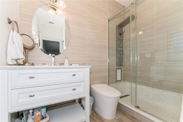 bathroom with toilet, tile walls, an enclosed shower, and vanity