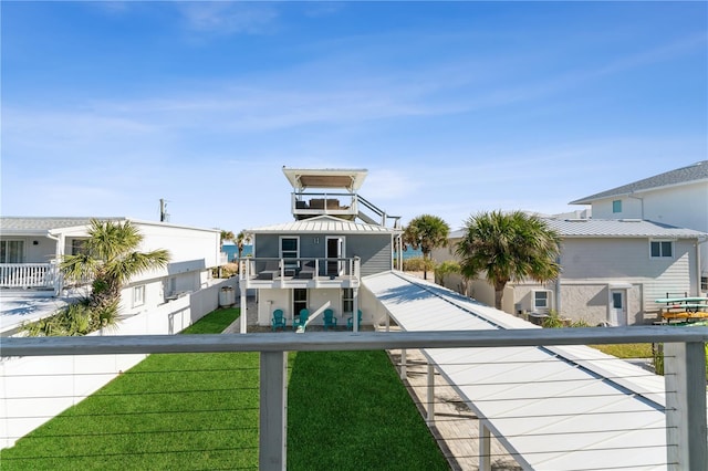 rear view of house featuring a lawn and a balcony