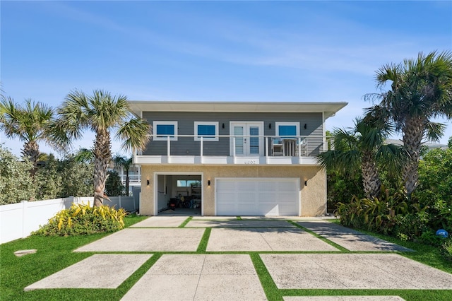 raised beach house featuring a garage and a balcony