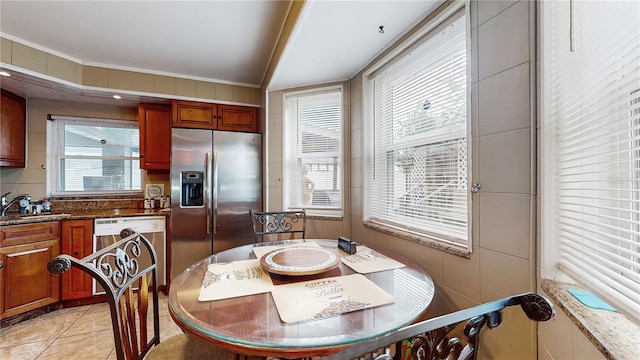 dining room featuring sink, light tile patterned floors, and crown molding