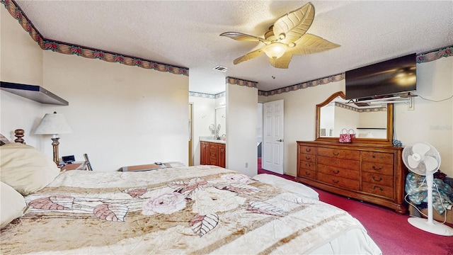 bedroom featuring a textured ceiling, ceiling fan, carpet, and connected bathroom