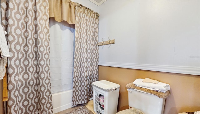 bathroom with toilet and shower / bathtub combination with curtain