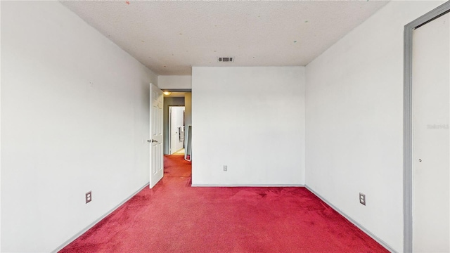 unfurnished room with a textured ceiling and carpet