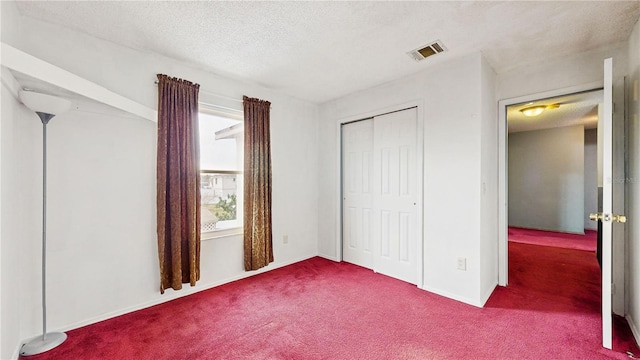 unfurnished bedroom featuring carpet, a closet, and a textured ceiling