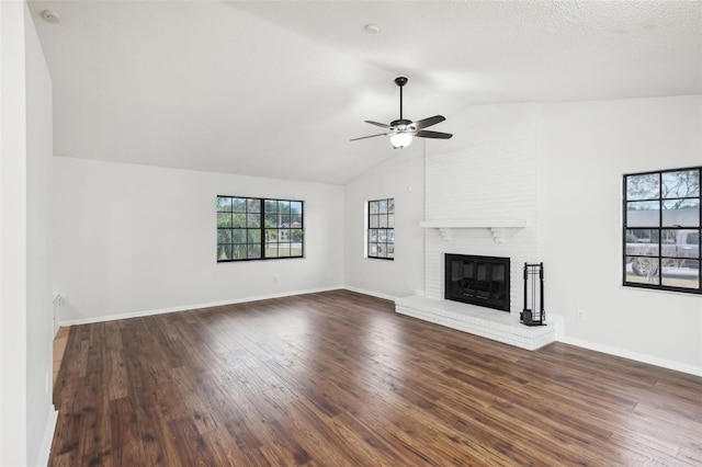 unfurnished living room with vaulted ceiling, dark wood-type flooring, a fireplace, and ceiling fan