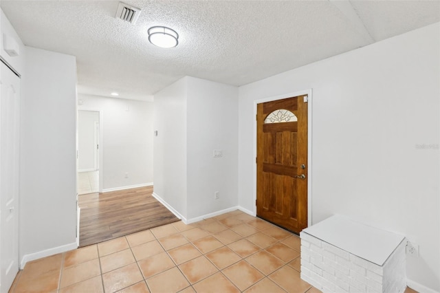 tiled foyer featuring a textured ceiling