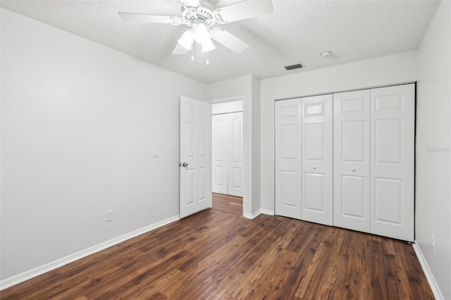 unfurnished bedroom featuring a textured ceiling, ceiling fan, dark hardwood / wood-style flooring, and a closet